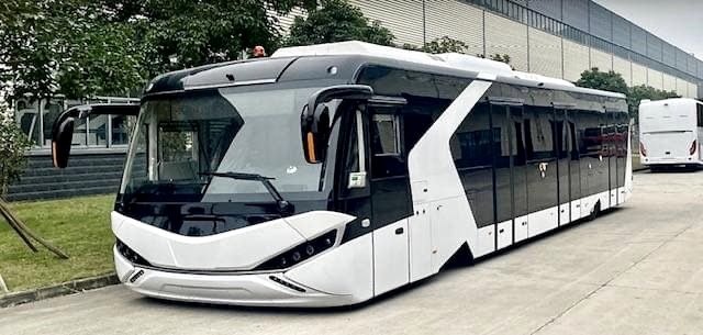Futuristic white articulated electric bus photographed outdoors